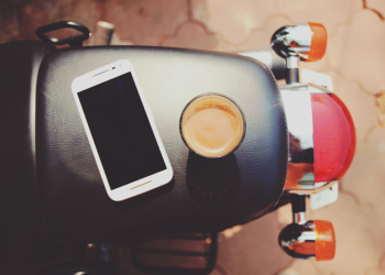 iphone on top of motorcycle with coffee